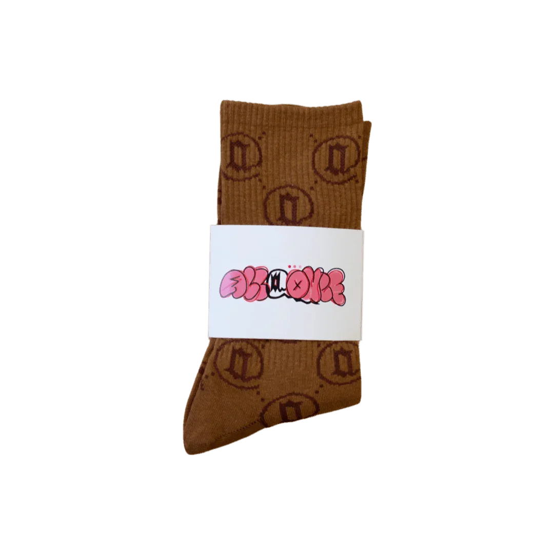Brown monogram socks with circular pattern and pink graphic label, laid on a flat background.