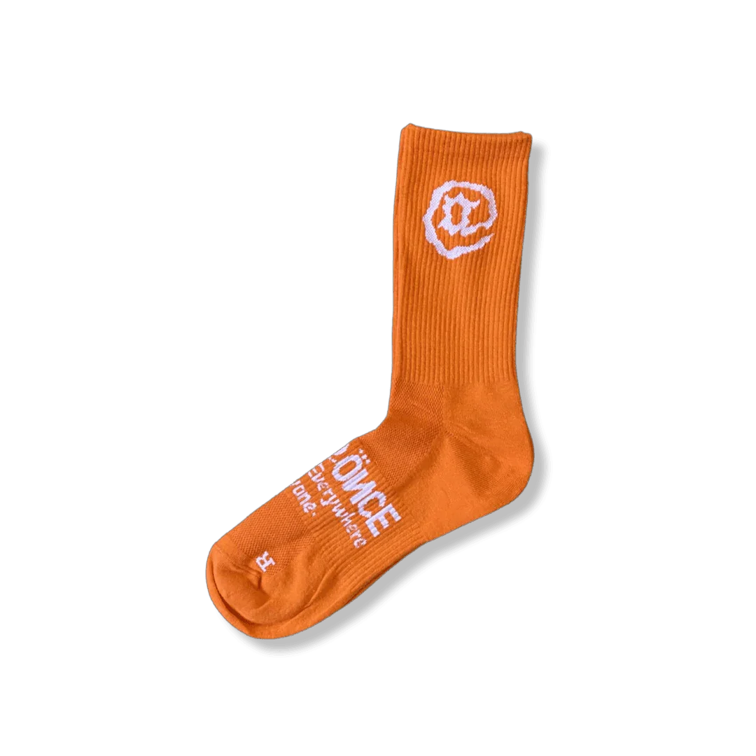 Orange crew sock with white smiley face and text design, single sock on plain background