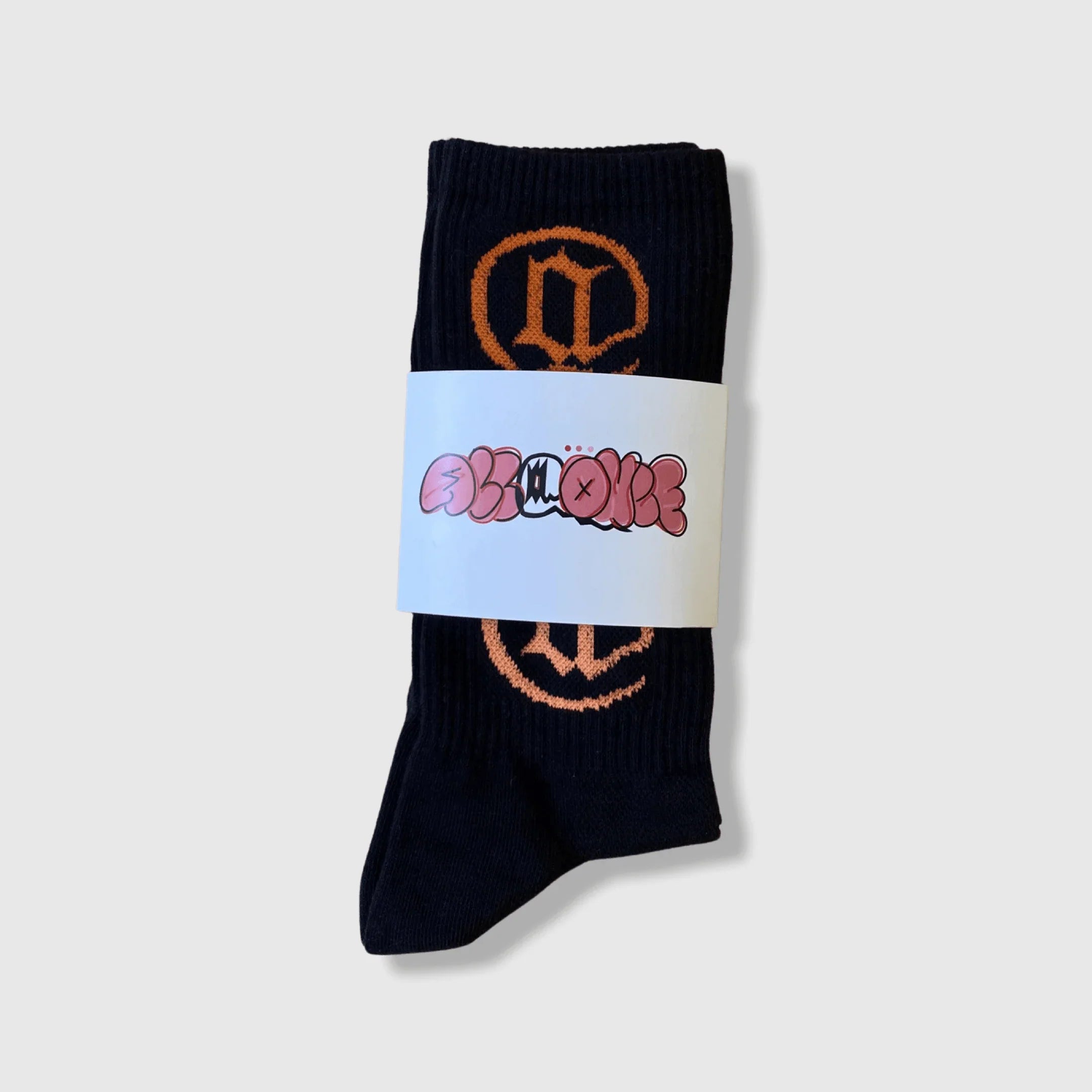 Black crew socks with orange graphic design, packaged with a decorative label.