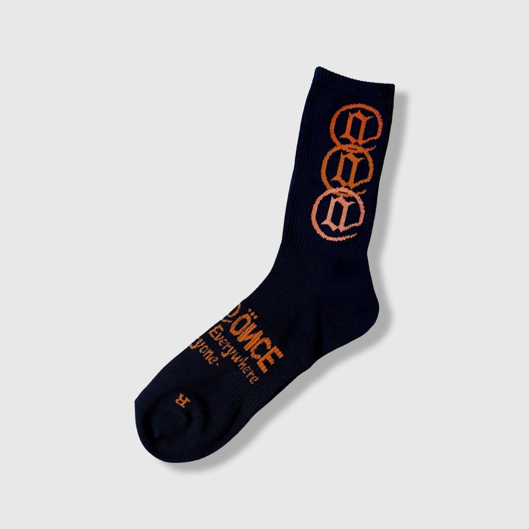 Black crew sock with orange graphic symbols and text, modern streetwear design