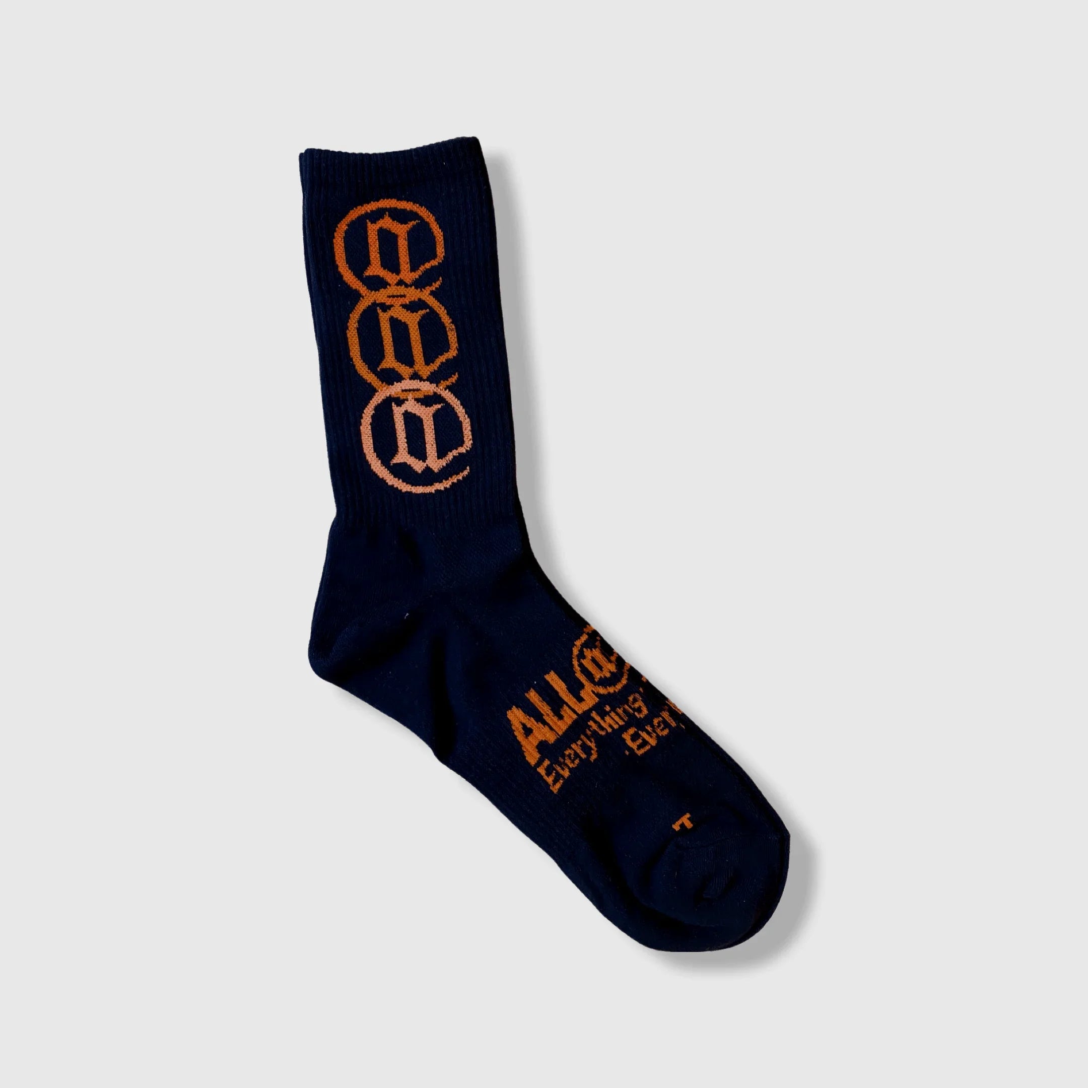 Navy blue crew sock with orange lettering and graphic design, streetwear style